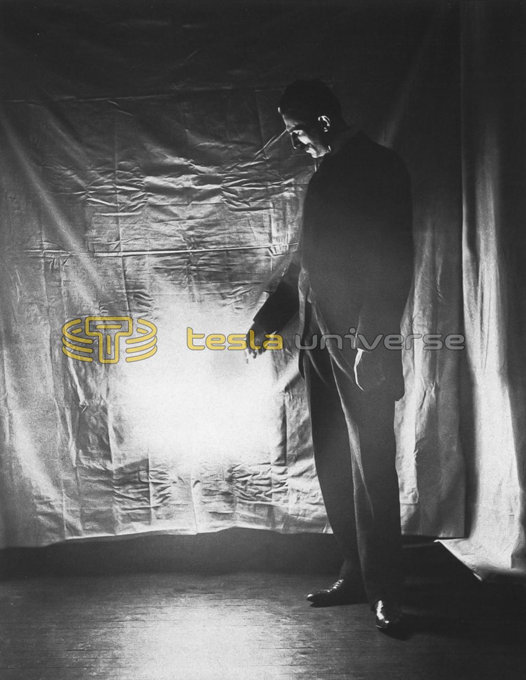 Tesla holds a highly evacuated, gas-filled tube, powered by one of his high-frequency oscillators